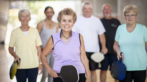 Seniors holding pickleball paddles